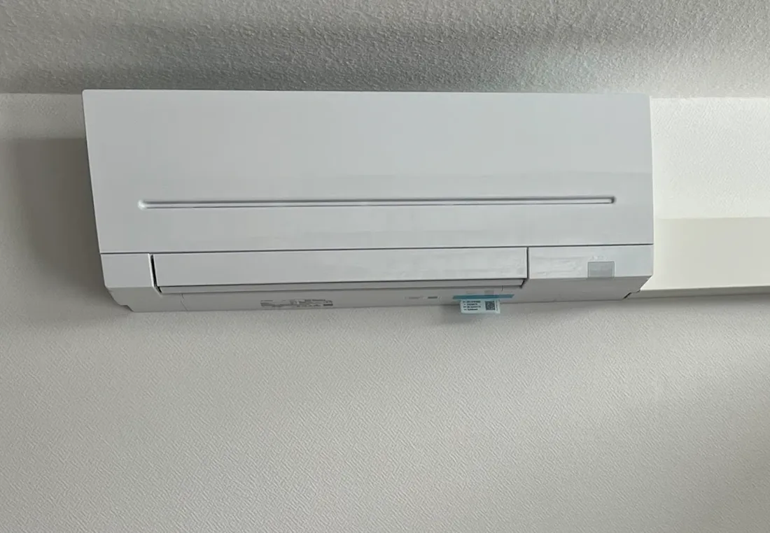 Weißes Split-Innengerät über der Fensterfront in einem Schlafzimmer